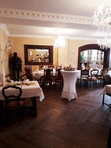 Steinbach am WaldAntikhotel Steinbacher Hof的一间带桌椅和吊灯的用餐室