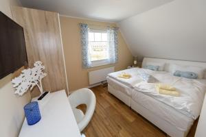 博恩Premiumhaus Bodden und Mehr-Brise的卧室配有白色的床和窗户。