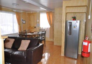 纳塔列斯港卡瓦尼亚斯巴塔哥尼亚英斯图公寓的带沙发和冰箱的客厅