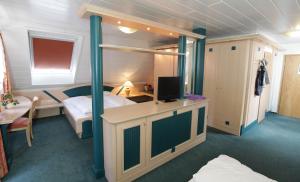 涅德托辛根克罗恩酒店的一间卧室配有双层床和电视。