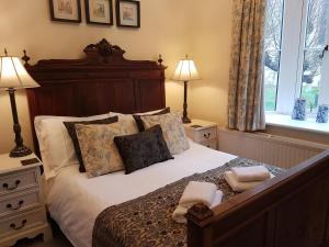 东格林斯特德哥特式酒店的一间卧室配有一张大床、枕头和两盏灯。