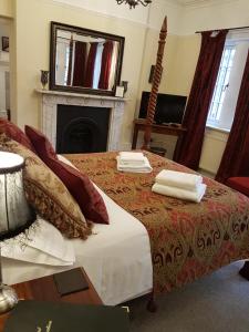 东格林斯特德哥特式酒店的一间卧室配有一张床,上面有两条毛巾
