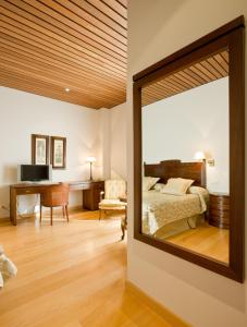 Argamasilla de Alba阿尔巴酒窖庄园酒店的卧室内的镜子,配有一张床和一张书桌