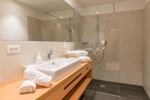 塞纳莱斯唐资酒店的浴室配有白色水槽和淋浴。
