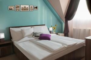 包姚Hotel Elizabeth的一张白色的大床,上面有紫色枕头