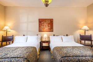 波帕扬丹恩修道院酒店的酒店客房设有两张床和两盏灯。