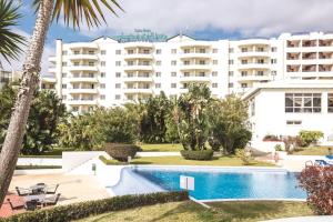 丰沙尔阿约达花园套房酒店的大楼前设有游泳池的酒店