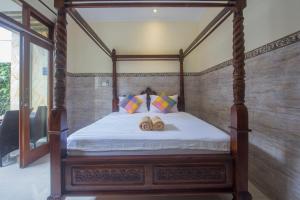 乌布杰普巴厘岛乌布民宿的一间卧室配有一张四柱床和两张木柴