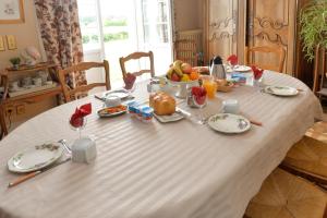 圣马丹勒博博福特之黎明住宿加早餐旅馆的一张桌子,上面有白色的桌布,上面有食物