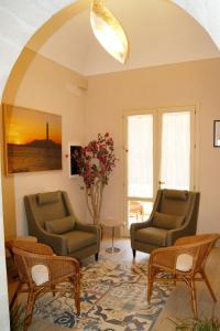 法维尼亚纳Albergo Bouganville的客厅配有两把椅子和一张桌子