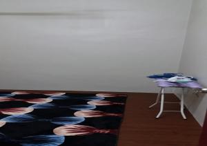 马六甲巴图贝伦丹度假屋的一间铺在地板上的地毯和一张桌子的房间