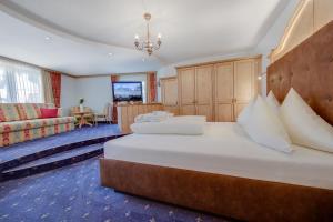 伊施格尔Hotel Albona的一间卧室配有一张大床和一张沙发