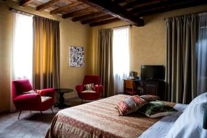 卡代奥卡思娜斯柯迪娜酒店的一间卧室配有一张床、两把椅子和电视