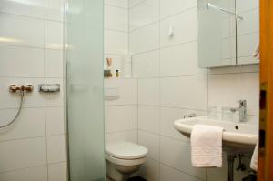 滨湖波德斯多夫Gästehaus Schmidt的白色的浴室设有卫生间和水槽。