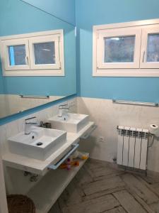 圣马尔塔奥尔蒂盖拉Celtigos Beach Resort的一间带两个盥洗盆和两个窗户的浴室
