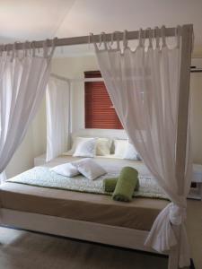 格兰高伯Villa Kreola的卧室内的一张带白色窗帘的床