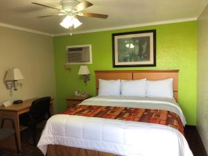 Kingman柯帕汽车旅馆的一间卧室配有一张带绿色墙壁的床