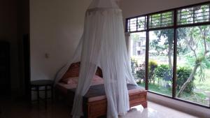 乌布阿尔加纳稻田简易别墅酒店的一间卧室配有一张带蚊帐的床