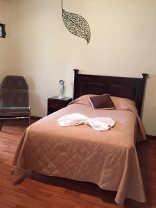 危地马拉康福特旅舍的一间卧室配有一张床,上面有两条毛巾