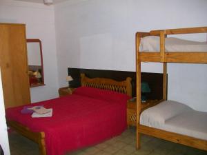 米娜克拉韦罗Hosteria Columbia的一间卧室配有两张双层床和红色床罩