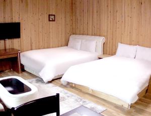 茂朱姆居度假屋的一间卧室配有两张床、一张桌子和一张四柱床。