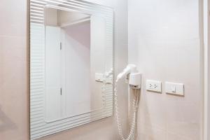 乔木提恩海滩阳光海滩酒店的一间带镜子的浴室和一部电话