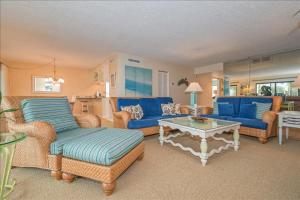 博卡格兰德Sea Oats 337 Apartment的客厅配有蓝色的沙发和咖啡桌