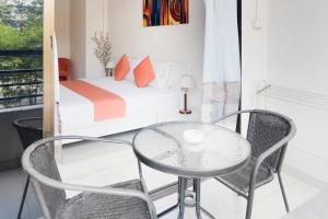 乔木提恩海滩阳光海滩酒店的配有床和玻璃桌及椅子的房间