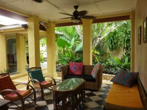飞鱼湾Villa Papaya的一个带椅子和沙发的门廊