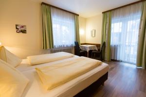 巴特霍夫加施泰因Appartementhaus Lafenthaler mit kostenlosem Eintritt in Alpentherme的酒店客房设有两张床和一张桌子。