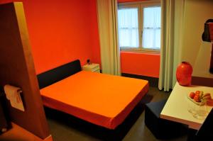 萨尔泰阿诺艾列奇中心酒店的小房间设有橙色的床和桌子