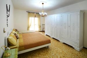 贝内瓦吉恩纳Bene Vagienna Holiday House的一间卧室配有一张带白色橱柜和吊灯的床。