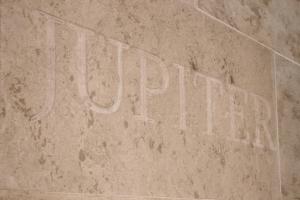 巴尔奇克Family Hotel Jupiter的墙上的标志,上面写着字谜