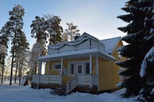 海尔迈Laiskan Kartano的屋顶上积雪的黄色房子