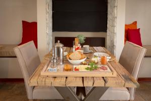 斯瓦科普蒙德Driftwood Guesthouse的一张木桌,上面有盘子的食物