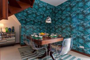 里斯本bairro alto view point 3 bedrooms chalet的一间设有桌子和绿色壁纸的用餐室