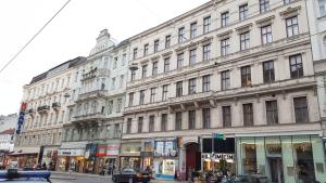 维也纳金马达拉膳宿酒店的一条有汽车的城市街道上白色的大建筑