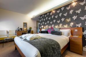伦敦布鲁姆斯伯里大使酒店的一间卧室设有两张床和鲜花墙