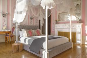 波尔图Boavista Eco-Luxury House的卧室配有白色的天蓬床和壁炉