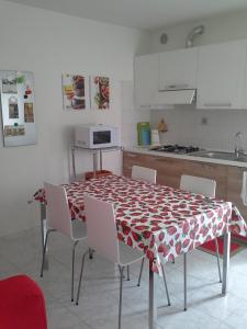 博尔索-德尔格拉帕萨尔维亚蒂莫假日公寓的厨房配有桌椅和桌布