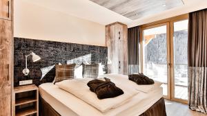 圣安东阿尔贝格Mountain Spa Residences的一间卧室设有两张床和大窗户