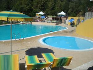里奥马里纳坎纳俳野营村酒店的一个带椅子和遮阳伞的大型游泳池