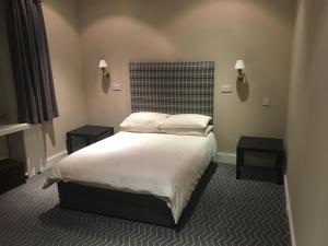 格拉斯哥克罗克斯顿酒店的一间卧室配有一张带两张桌子和两盏灯的床。