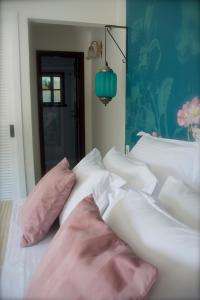 布希奥斯巴尔萨泽别墅酒店的床上配有粉色和白色枕头的床