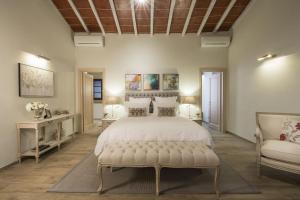 卡斯德尔诺沃贝拉登卡Borgo Argiano的一间卧室配有一张大床和一张沙发