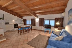 帕维亚卡西内托公寓式酒店的一间带蓝色沙发的客厅和一间厨房
