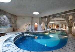 格雷梅Anatolian Houses Cave Hotel & SPA的一座带拱门的建筑里的大型游泳池