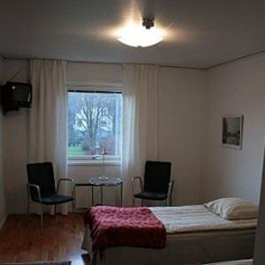 GrundsundRågårdsvik的一间卧室配有一张床、两把椅子和一个窗户