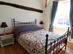 SwanwickJust A Cottage, Newlands Farm的一间卧室配有一张带床罩的床和窗户