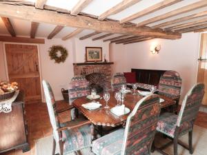 SwanwickJust A Cottage, Newlands Farm的一间带桌椅和壁炉的用餐室
